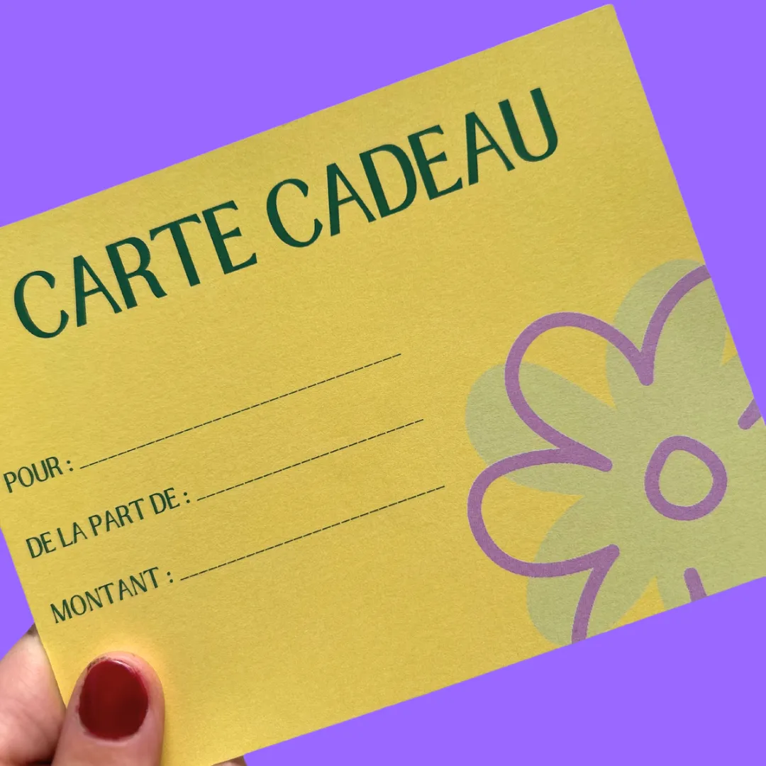 Carte cadeau jaune inclinée, avec des champs à remplir et un motif floral violet, tenue par une main.